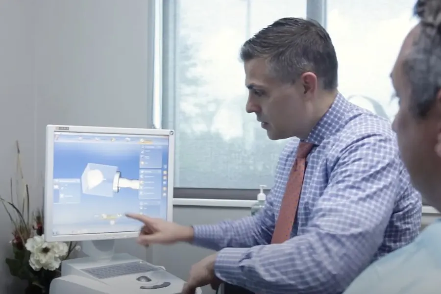 Dr. Ben Tindal designing a restoration on screen with a patient.